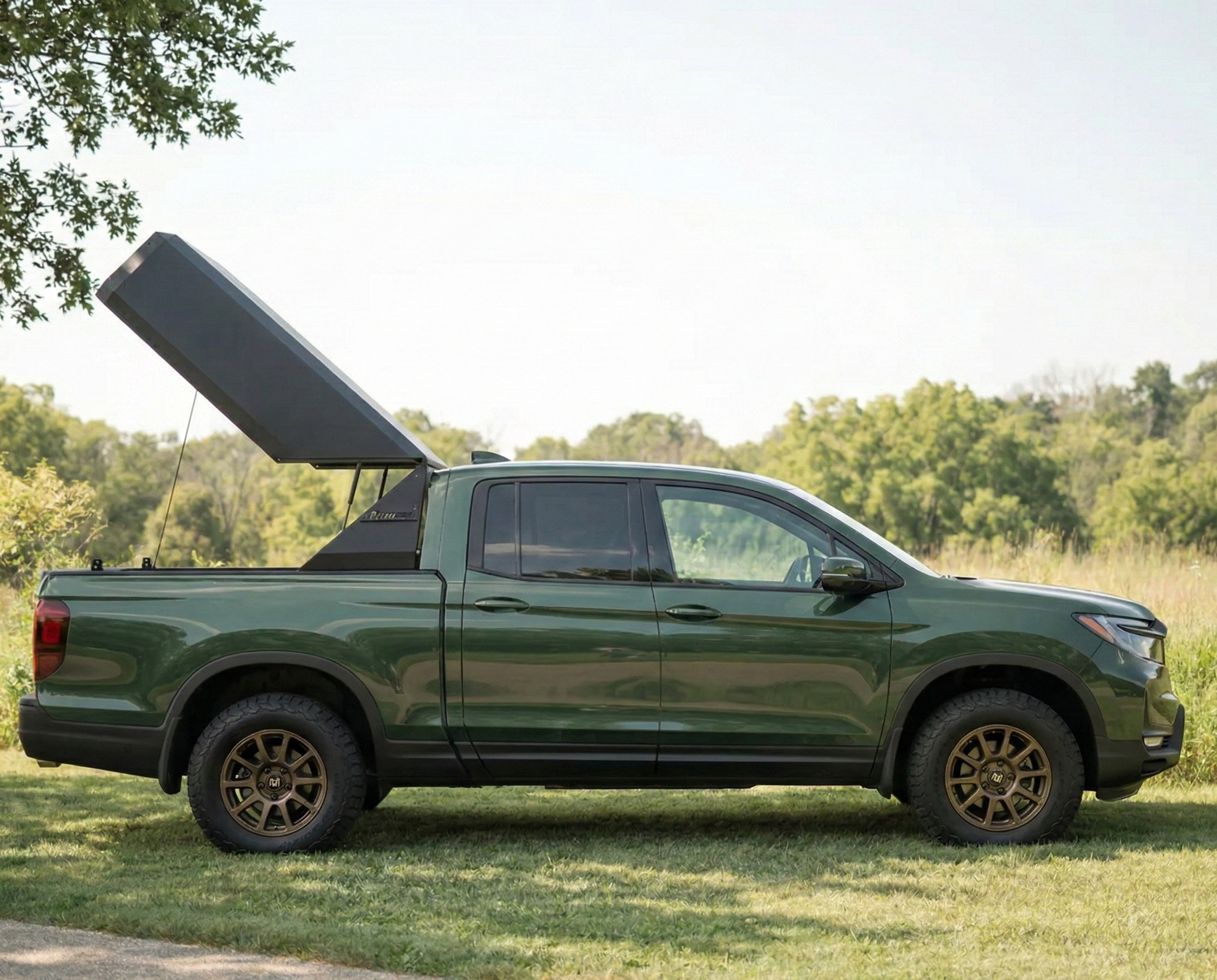 Green honda ridgeline pickup truck with matrix GT open on parked on grass